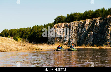 Il gruppo di amici sul fiume in derive da roccia Foto Stock