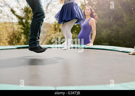 Sezione bassa del padre e figlia rimbalzare sul trampolino Foto Stock