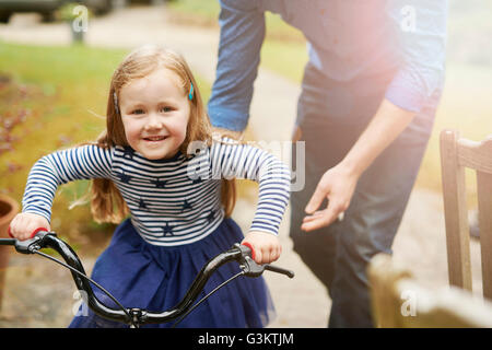 Padre figlia di insegnamento per guidare la bicicletta Foto Stock