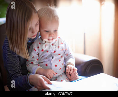 Ragazza giovane la lettura al fratello bambino Foto Stock