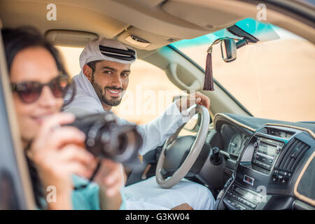 Turista femminile in fuoristrada nel deserto scattare fotografie, Dubai, Emirati Arabi Uniti Foto Stock
