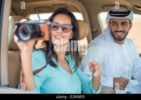 Turista femminile in fuoristrada nel deserto scattare fotografie, Dubai, Emirati Arabi Uniti Foto Stock