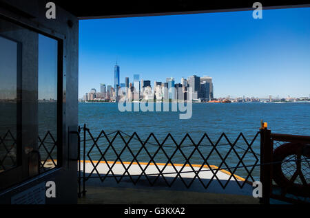 La parte inferiore di Manhattan skyline visto da Staten Island Ferry Crossing del porto di New York Foto Stock