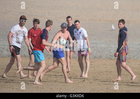 Un gruppo di giovani uomo giocando a rugby su Fistral Beach in Newquay, Cornwall. Foto Stock