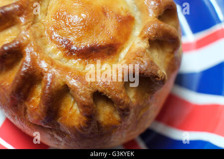 Tradizionale a mano torta di maiale su union jack flag piastra Foto Stock