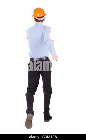 Vista posteriore di ingegnere in esecuzione nel casco. Ragazzo a piedi in movimento. Vista posteriore di raccolta di persone. Vista posteriore di persona. Isolato su sfondo bianco. Caposquadra corre verso l'edificio. Foto Stock
