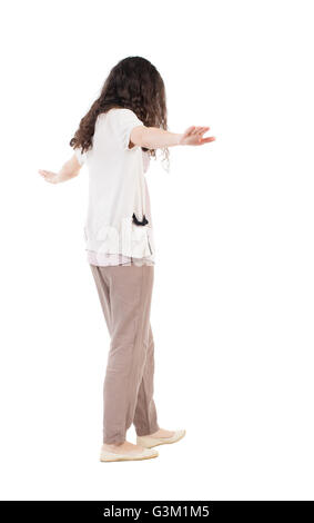 Vista posteriore della donna è in equilibrio su una fune. In piedi giovane ragazza in parka. Vista posteriore di raccolta persone. vista posteriore di persona. Isolato su sfondo bianco. La ragazza va su una fune funambolo Foto Stock