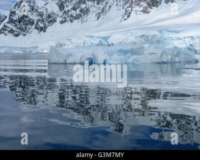 Un iceberg riflessa nelle calme acque blu di Antartide Foto Stock