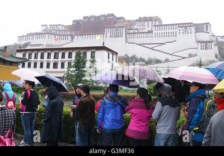 Lhasa, la Cina della regione autonoma del Tibet. Xiii Giugno, 2016. I turisti di attendere nella pioggia per immettere il Potala a Lhasa, capitale del sud-ovest della Cina di regione autonoma del Tibet, 13 giugno 2016. Il Tibet ha inserito la sua alta stagione turistica. © Purbu Zhaxi/Xinhua/Alamy Live News Foto Stock