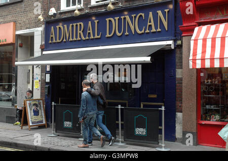 Londra, Regno Unito. Xiii Giugno, 2016. Una coppia gay a piedi a braccetto passato in Soho il giorno dopo l'impulso di tiri in Orlando. La folla si raccolgono al di fuori dell'Admiral Duncan pub per rilasciare 50 palloncini in memoria di quelle scattate presso il club di impulso in Orlando. Credito: JOHNNY ARMSTEAD/Alamy Live News Foto Stock