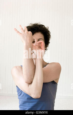 Femmina praticante yoga eseguendo un mudra (la posizione della mano) in studio Foto Stock