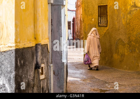 Donna Marocchina in una Djellaba, abito tradizionale, nella medina di mura di cinta città costiera di El Jadida, Marocco Foto Stock