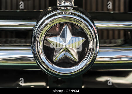 Chrome vintage della stella sulla griglia del radiatore di una vecchia auto closeup. Foto Stock