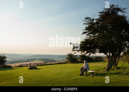 Persone anziane signore seduto sul banco in country park, Buriton, Hampshire, Inghilterra, Regno Unito, Europa Foto Stock