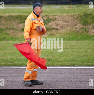 Via maresciallo con bandiera rossa in corrispondenza di un evento motoristico. Foto Stock