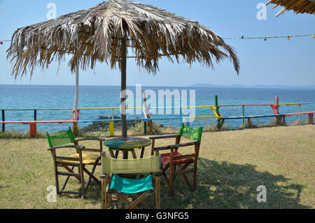 Bar tavoli e sedie sotto ombrellone con vista mare Foto Stock