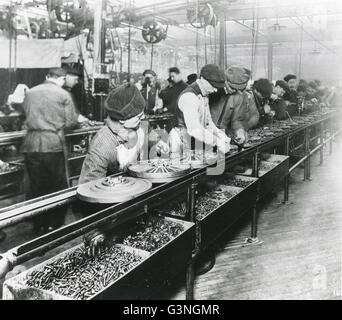 Questi lavoratori nel 1913 presso la Ford Motor Company impianto realizzato in storia industriale con la costruzione di un volano magnete su un gruppo di spostamento linea. Qui essi sono sulla linea di montaggio. Foto Stock