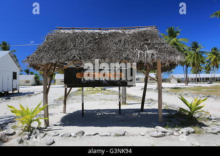 Segno di scuola sotto foglie di palmo tetto, Isola di Natale, Kiribati Foto Stock