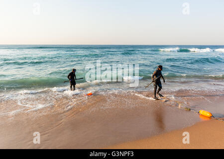 La pesca subacquea subacquei preparati pronti sulla spiaggia entrata nuotare in acque oceaniche. Foto Stock