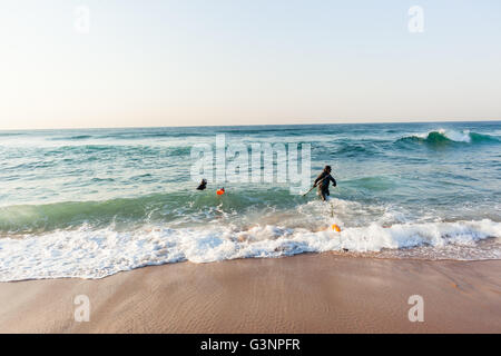 La pesca subacquea subacquei preparati pronti sulla spiaggia entrata nuotare in acque oceaniche. Foto Stock