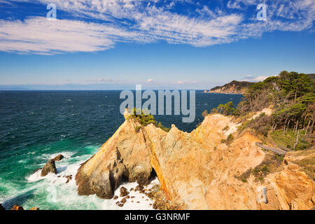 Il Koganezaki Cape (黄金崎) sulla Penisola di Izu in Giappone con il Monte Fuji in lontananza. Fotografato su una bella luminosa Foto Stock