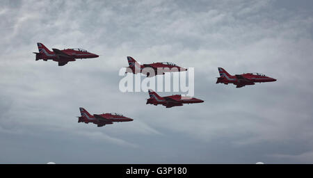 5 RAF Freccia Rossa aviogetti Hawk in formazione con un interessante cielo molto nuvoloso in background Foto Stock