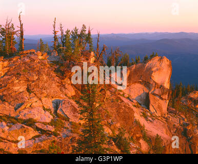 Stati Uniti d'America, Idaho, Nezperce National Forest, Sunrise riscalda sperone di roccia sulla manopola bruciato e boscoso creste e valli a nord-ovest. Foto Stock