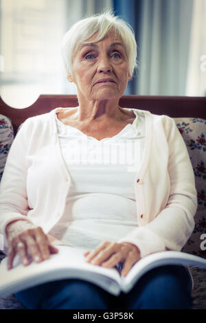 Malinconici blind donna seduta con il braille prenota al giro Foto Stock