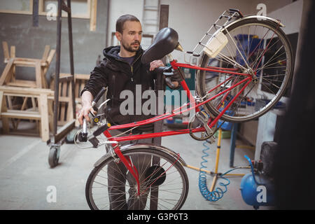Mechanic la riparazione di una bicicletta Foto Stock