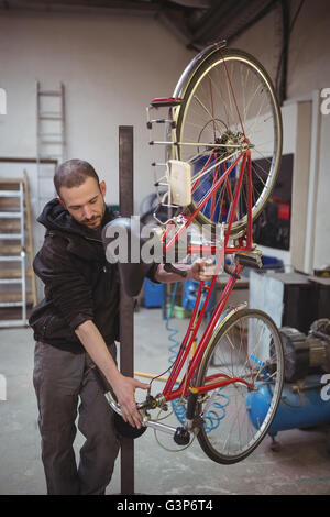 Mechanic la riparazione di una bicicletta Foto Stock