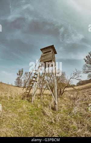 Retrò tonica obiettivo fisheye foto di un pulpito di caccia su un campo, Polonia. Foto Stock