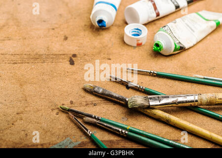 Pennelli e colori posa su una tabella di studio. Foto Stock