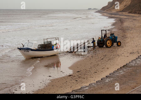 Utilizzando un trattore per il traino di una barca di granchio di mare. Foto Stock