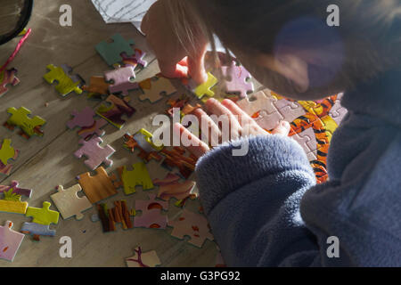 Ragazza giovane la costruzione di un puzzle di mattina Foto Stock