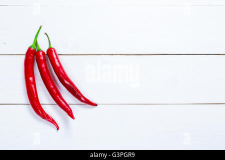 Bellissimo sfondo gruppo di tre chili peppers sulle lavagne bianche con spazio libero per voi il testo Foto Stock