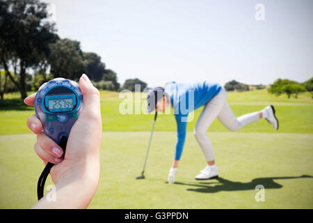 Immagine composita di una donna tenendo un cronometro per misurare le prestazioni Foto Stock