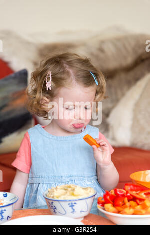 Due anno vecchia ragazza a chi non piace mangiare le verdure, England, Regno Unito Foto Stock