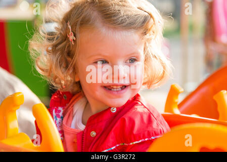 Blonde due anno vecchia ragazza godendo di una fiera ride, England, Regno Unito Foto Stock