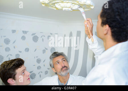 Giovane pittura una decorazione del soffitto Foto Stock