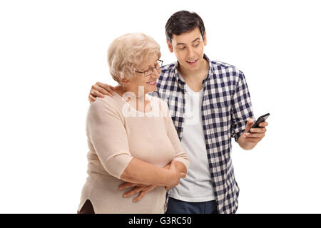Giovane uomo che mostra qualcosa da una donna anziana sul suo telefono delle cellule isolate su sfondo bianco Foto Stock