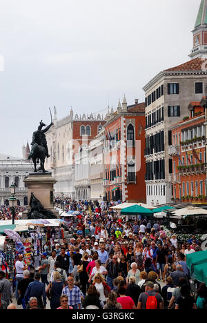 Riva degli Schiavoni, Venezia, Italia. Migliaia di turisti affollano Venezia in tutte le stagioni. Sullo sfondo la statua equestre di Vittorio Emanuele II . Foto Stock