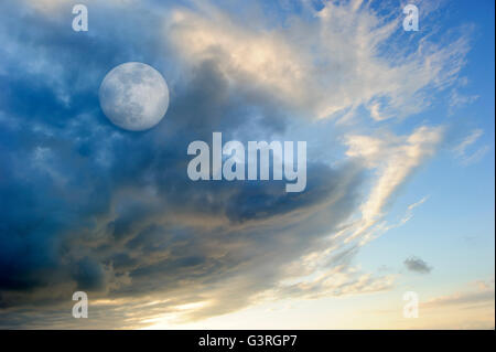 Luna nuvole del cielo è una vivace fantasia surreale come cloudscape con il celeste etereo Full Moon Rising tra le nuvole. Foto Stock