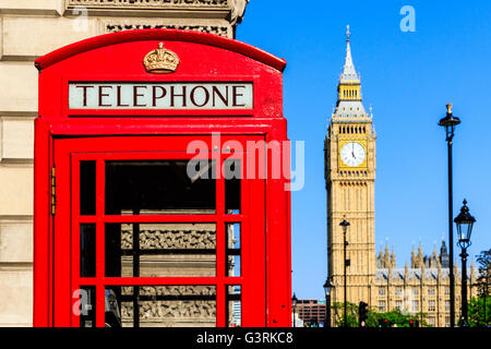 Iconico telefono rosso scatola con il Big Ben e lampade stradali contro il cielo blu in background Foto Stock