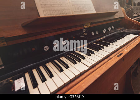 Rotture di antico pianoforte con note nel capannone con in primo piano sfocato Foto Stock