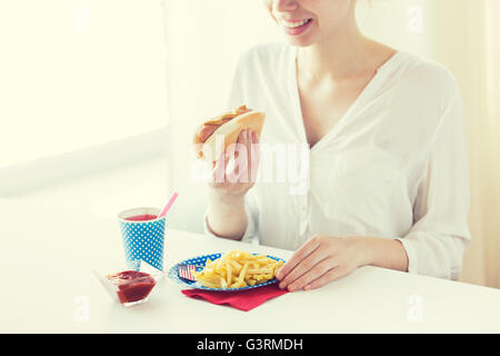 Close up della donna mangiare hotdog e patatine fritte Foto Stock