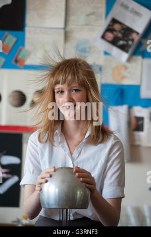 Una raccolta di capelli schoolgirl usando un Van de Graaff del generatore durante una lezione di fisica. In Inghilterra. Regno Unito Foto Stock