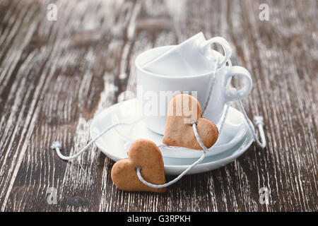 Il giorno di San Valentino del concetto. Due a forma di cuore biscotti e un paio di tazze da caffè Foto Stock