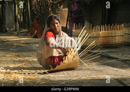 Una donna che fa un cesto di bambù .Mangla,Bangladesh. Foto Stock