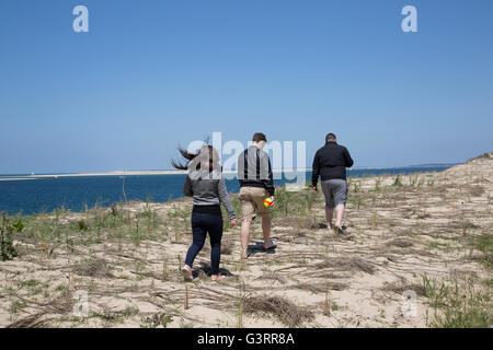 Persone calpestando area protetta con erba Marram piantati per aiutare a stabilizzare le dune di sabbia Grande Duna del Pyla Francia Foto Stock