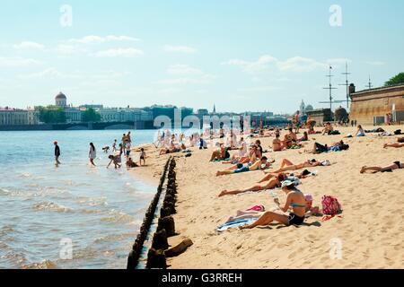 San Pietroburgo Russia. Prendere il sole sulla spiaggia al di fuori delle mura della fortezza di Pietro e Paolo su Zayachy isola sul fiume Neva Foto Stock